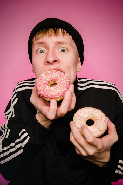 Pink and black.  two donuts.  pink and white.  a cap.  costume.  eating food Eating Donut Pose, People Eating Reference, Food Poses, Dunkin Donut, Life Drawing Model, Drawing Models, Modeling Poses, Eat Cookies, Adidas Hat