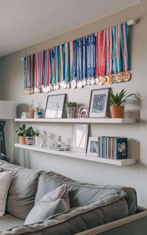 A modern living room with a wall-mounted display showcasing an array of race medals. Diy Medal Display, Runner Medal Display, Diy Medal, Display Medals, Medal Display Ideas, Hanging Medals, Marathon Medal Display, Race Medal Displays, Sports Medal Display