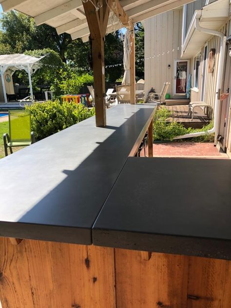 This concrete bartop was customized for the existing wood bar in this backyard! #concrete #concretecountertops #concretefurniture #wisconsinconcrete #concretelife #wisconsin #gfrc #fishstoneconcrete Concrete Bartop, Backyard Concrete, Outside Bar, Outside Bars, Bbq Island, Concrete Furniture, Wood Bar, Concrete Countertops, Firepit