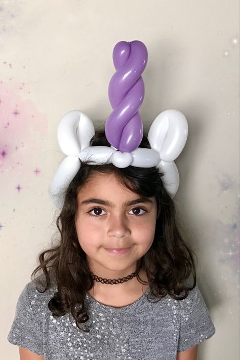 A girl wears a balloon unicorn horn and ears. The ears are white and the horn is purple. Easy Balloon Twisting, Balloon Animal Tutorial, Diy Balloon Animals Easy, Easy Balloon Animals Step By Step, Easy Balloon Animals, Balloon Tutorials, Balloon Unicorn, Balloon Hats, Balloon Crown