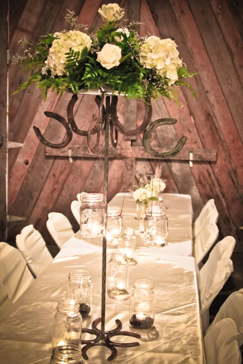 Arrangements of flowers were set onto the top of the metal piece and ... Western Wedding Centerpieces, Hay Bale Decorations, Quince Centerpieces, Western Centerpieces, Charro Wedding, Western Wedding Decorations, Simple Beach Wedding Ideas, Mexican Wedding Ideas, Horseshoe Ideas