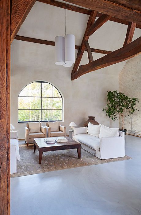 Fantastic converted house with original clock tower and beams. Open plan space with concrete floors. Crittall doors and lime plaster walls. Kitchen/dining area with lots of light. Living area with tall ceilings, beams and white exposed brick wall. Off White Limewash Wall, Limewash Walls Concrete Floor, Interior Plaster Walls, Lime Plaster Kitchen, Limewash Walls Dining Room, Lime Wash Accent Wall Living Room, Natural Plaster Walls, White Lime Wash Walls, Lime Wash Floor