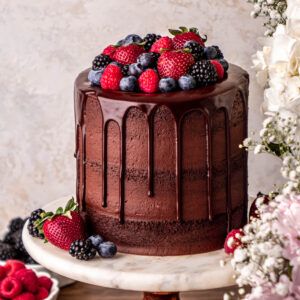 chocolate cake with chocolate ganache drip topped with strawberries, blueberries, raspberries and blackberries. Chocolate Cake Topped With Strawberries, Cute Cakes With Strawberries, Rustic Chocolate Cake Birthday, Chocolate Ganache Cake With Strawberries, Chocolate Berries Cake, Chocolate Birthday Cake With Fruit, Chocolate Cream Cake Design, Chocolate Cake Strawberries, Chocolate Berry Cake Decoration