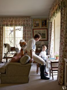 In the playroom, the curtains are of a Bennison linen edged with Colefax and Fowler fringe, and the walls are covered in a Cole & Son wallpaper. Tom sits on a sofa dressed in a Titley and Marr fabric. Son Wallpaper, English Estate, Drawing Rooms, Traditional Chic, English Interior, Cole And Son Wallpaper, English Country Decor, English Country Style, English Decor