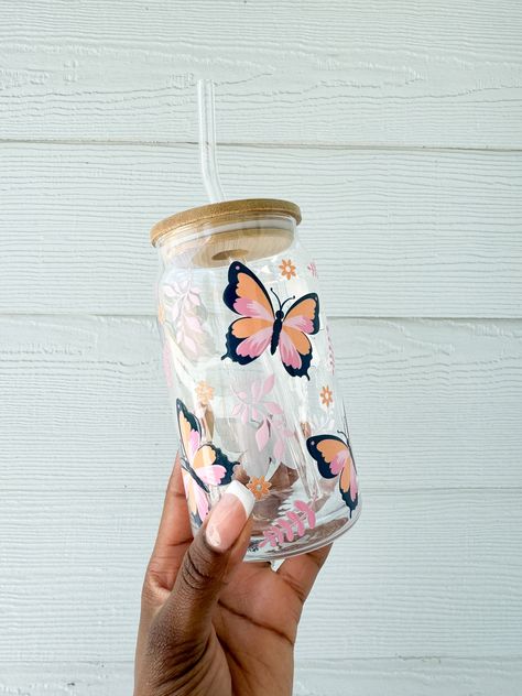 Pink Butterfly Glass Can  The perfect glass for any drink, any time of day! Iced coffee, beer, wine, smoothies, juice, and more! Glass drinkware featuring the cutest butterfly design.  ABOUT THE GLASS CAN - 16 oz glass can - Glass is made to order with UV DTF Decal SHIPPING Glass cans are made to order; kindly allow 5-7 processing days for your order to ship. Order is packed with bubble wrap for safety in transit. Shipping is USPS with tracking. Domestic shipping only.  This listing is for ONE glass. It is the pink butterfly design. STRAW AND LID NOT INCLUDED UNLESS UPGRADED TO THE SET. CARE INSTRUCTIONS:  Gentle hand wash only, not to be put in the dishwasher or microwave. Care instructions are included with your order. I create happy goods to make life more joyful! Designed in Orlando, F Drinking Glass Aesthetic, Aesthetic Glass Cup Design, Vasos Aesthetic, Glass Cup Aesthetic, Cute Glass Tumbler With Straw, Remove Bleach Stains, Aesthetic Mugs, Clear Mug, Flower Glass Cup