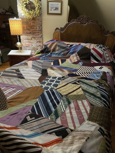 "It is not very often we come across such an unusual quilt.  This quilt was made here on the Island using a variety of men's ties - the colours, patterns and textures are all different.  The ties were taken apart and cut and assembled and top stitched. Makes us think of a crazy quilt.    Some of these ties have patterns/material from the 1950s or possibly earlier.  You can tell that some were quite wide.  We counted over  100 different ties.   The workmanship in this quilt is a work of art!  It is in great vintage condition -  a few small things were noticed - tiny pinhole in one tie and the material on another is a bit frayed (there is a underlying piece protecting it (see last 2 photos).   The quilt has a small red binding all hand stitched and a rose coloured backing.    This quilt is v Necktie Quilt, Quilt Rack, Tie Quilt, Country Casual, Hanging Table, Men's Ties, Quilted Table Toppers, Crazy Quilt, Textile Arts