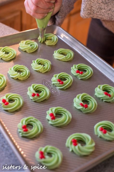 Wreath Spritz Cookies - Sisters and Spice...and everything nice Buttery Spritz Cookies Christmas, Piped Spritz Cookies, Christmas Spritz Cookies Decorating, Holiday Spritz Cookies, Swedish Spritz Cookie Recipe, Wreath Spritz Cookies, Spritz Christmas Cookies, Sprits Cookies Recipe, Christmas Press Cookies