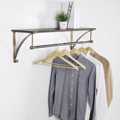 Stylishly display clothing in a home or retail environment with this 35-inch wall-mounted coat and hat rack. Featuring a 35 x 12-inch shelf and 35-inch clothes hanger rod, this garment display shelf offers a perfect blend of space and style for merchandising clothing in a shop or providing decorative storage for coats, hats, and purses in the home entryway. Its rustic finish and bronze-tone metal construction are great for adding a decorative accent to any living space and can be easily installe Metal Floating Shelves, Shoe Storage Shelf, Hanging Bar, Wood Floating Shelves, Hanger Rack, Estantes Flotantes, Clothes Drying Racks, Hanging Clothes, Garment Racks