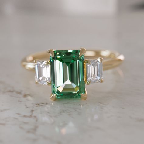 Read the Custom Ring Builder FAQ's to learn more → To build your ring: 1. Select a stone and add it to your cart 2. Select your setting and add it to your cart. 3. Your custom ring is made. The Atlahua Green Sapphire Engagement Ring, is a modern three stone engagement ring ring featuring a center emerald cut green Sapphire accented by two emerald cut lab diamonds. Crafted with precision, the custom sourced emerald cut sapphire takes center stage and is artfully set on a minimalist round gold ban Ethical Engagement Ring, Green Sapphire Engagement, Green Sapphire Engagement Ring, Wedding Band Styles, Classic Engagement Ring, Three Stone Engagement Ring, Classic Engagement, Stone Pictures, Classic Engagement Rings