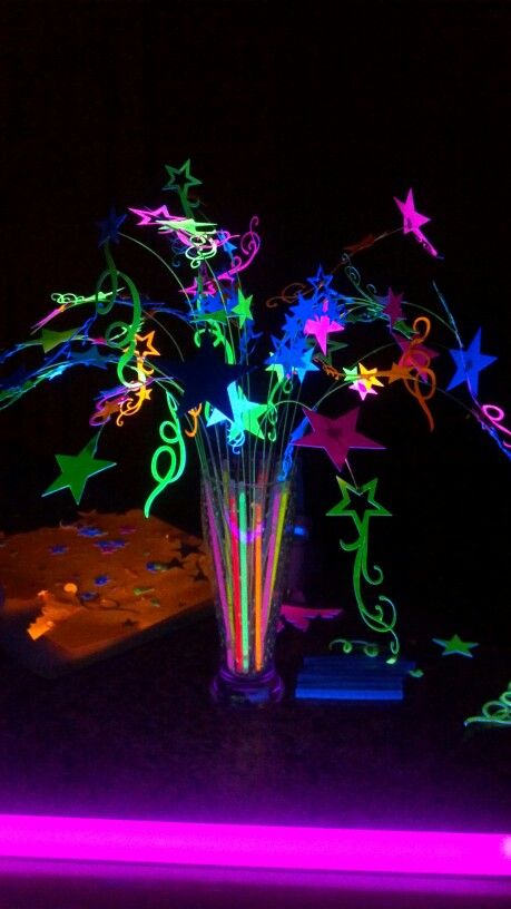 Young womens "Let your talents glow" theamed night in Excellence Centerpiece. All lit up by black light. Stars are made from neon poster board. Glow stick are in base, not cracked to glow. Black light lights them up. Light Up Centerpieces Diy, Neon Table Centerpieces Glow Party, Glow In The Dark Table Centerpiece, Glow Table Decorations, Glow Stick Decorations, Glow Party Table Centerpieces, Glow In Dark Centerpieces, Glow In The Dark Party Centerpieces, Neon Glow Centerpieces