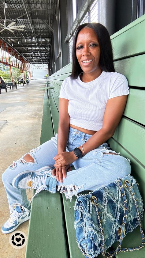 Girl sitting on the bench with one leg folded wearing a white ribbed cropped top, distressed jeans, and a denim crossbody bag Jean Jordans Outfit, Denim Sneakers Outfit Women, Denim Jordan 1s Outfit Women, Retro 1 Outfit Jordan Women, Denim Jordan 1s Outfit, Jordan 1s Outfit Women, Air Jordan Denim, Air Jordan 1 Denim, Jordan 1 Denim