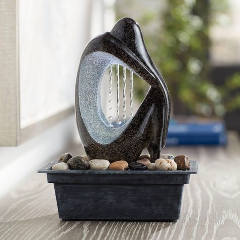 PRICES MAY VARY. 10" high x 7" wide x 5" deep. Weighs 8.2 lbs. Modern Silhouette LED tabletop fountain with 4-LED light cluster. Faux black marble stone finish. Lightweight resin construction. Please note - item is black faux marble stone. Blue-tone in image is reflection of the LED light. Comes with water pump and 6-foot long cord. Easy to set up. An indoor/outdoor tabletop water fountain is a great way to add an exciting accent to your decor. This design features a carved stylized figure in si Table Top Water Fountains, Small Indoor Water Fountains, Faux Black Marble, Ceramic Fountain, Desk Fountain, Table Top Desk, Mini Fountain, Table Fountain, Resin Water