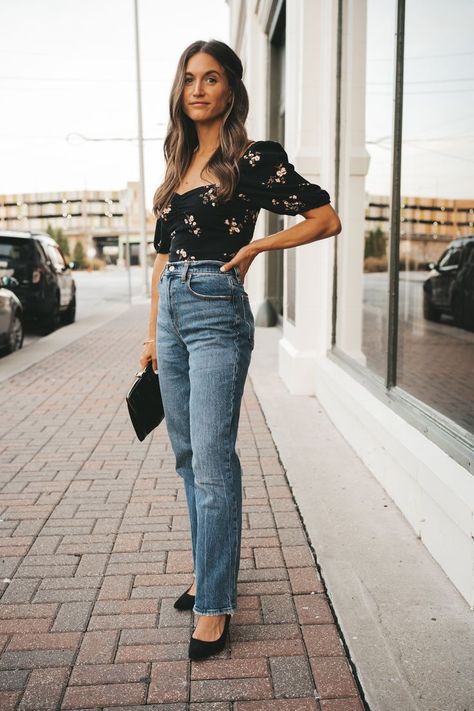 ashley wearing a black floral top, medium wash straight leg jeans, and black pumps holding a black clutch and standing on a sidewalk with red brick pavers next to the large window of a shop Jeans Date Night Outfit, Fall Date Night Outfit, Statement Fashion Pieces, Fall Date Night, Straight Leg Jeans Outfits, Outfits Jeans, Mom Jeans Outfit, Night Tops, Date Outfit Casual