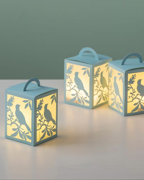 Light up your home with these festive DIY lanterns made using the Martha Stewart Cricut Explore Air 2. The easy-to-use machine is compatible with a variety of materials and is able to cut out intricate designs with accuracy. Shop Martha's full line of Cricut crafting supplies at Michaels. Diy Christmas Paper Decorations, Cricut Projects To Sell, Diy Christmas Paper, Paper Lanterns Diy, Paper Lantern Lights, Idee Cricut, Paper Christmas Decorations, Projets Cricut, Diy Lanterns