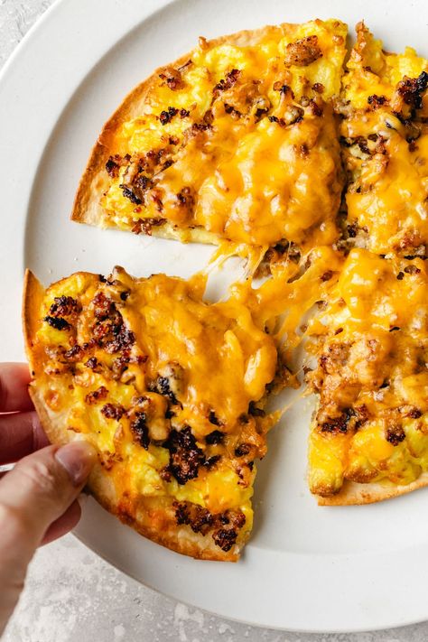 Enjoy a protein-packed start to your day with this delicious Breakfast Pizza Recipe. Featuring low-carb tortillas as our pizza crust, a cheesy, creamy sauce, scrambled eggs, crumbled sausage, shredded cheese, and any extra toppings you desire. Egg Pizza Breakfast, Paleo Keto Recipes, Breakfast Pizza Recipe, Cheesy Eggs, Tortilla Pizza, Low Carb Tortillas, Cheesy Sauce, Sausage And Egg, Breakfast Pizza