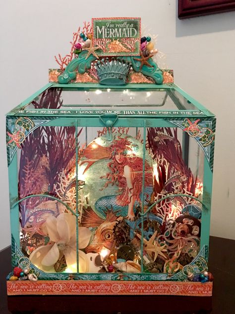 This is a candle lantern that I converted into mermaid display. I added lighting to the inside. Sea Diaroma, Mermaid Diorama, Mermaid Display, Captured Mermaid, Sea Scrapbook, Diaroma Ideas, Seafood Display, Shadow Box Kunst, Panorama Art