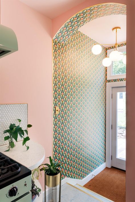 Create visual separation between the entryway and other rooms by using a bold wallpaper and a decorative light fixture. This maximalist, retro floral wallpaper and mid century modern chandelier separate the foyer from the kitchen. We added a window above the door to maximize natural light.  #design #designer #foyer #interiors #wallpaper #vintage #retro #maximalism Retro Maximalism, Natural Light Design, Retro Entryway, Retro Modern Kitchen, Maximalist Retro, Retro Floral Wallpaper, Closet Wallpaper, Wallpapered Entryway, Maximalist Kitchen