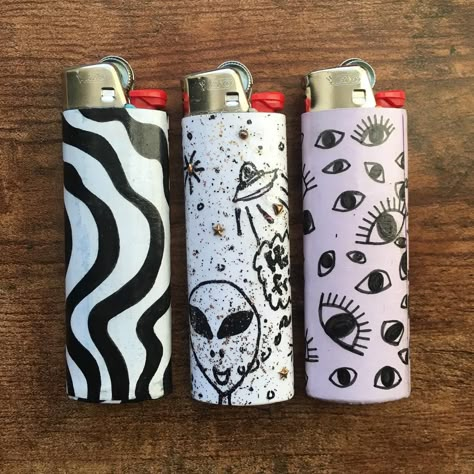 These guys get lit 🔥 Custom lighters made by: @tory.james and @val_keating . . . #radiantjanes #smallbusiness #makersgonnamake #makersmovement #womenworking #femaleartist #artisoninstagram #handmadefunthings #funkyart #biclighter #blackandwhite #eyes #alines #newyorkmade #madeinnewyork #littledrawing Lighter Art Diy, Painted Lighters Aesthetic, Diy Lighter Painting, Lighters Decorated Diy, Lighter Painting, Painted Lighters, Lighter Paintings Ideas, Lighter Art, Custom Lighters