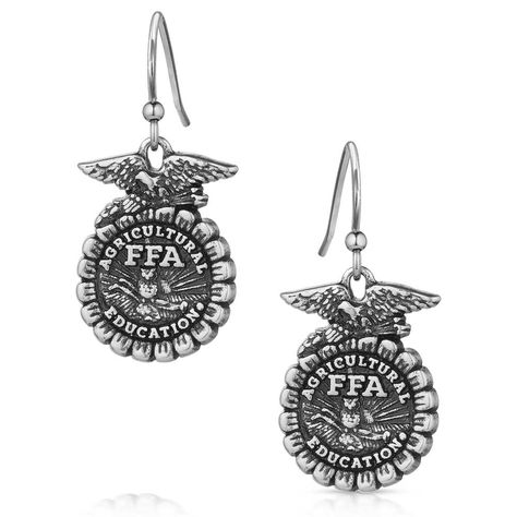 Show your love for the FFA Organization with the FFA Emblem Earrings. The earrings feature an etched FFA emblem in an antiqued silver tone. The earrings depict the FFA emblem in stunning detail. An etched eagle sits atop the cross section of corn. Through the center "Agriculture Education" and "FFA" are clearly visible. The rising sun serves as the backdrop for the plow and owl in the center. These earrings will make the perfect gift to any FFA member, advisor, and alumni in your life. The ... Ffa Teacher, Ffa Emblem, Ffa Banquet, Ag Teacher, Rodeo Jewelry, Country Vibe, Western Necklace, Western Necklaces, Agriculture Education