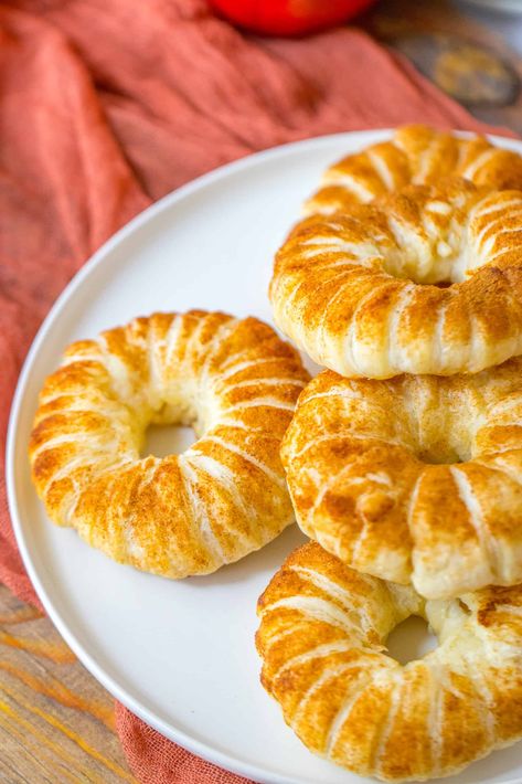 Sliced apple rings wrapped in a flaky crust and dusted with sweet and fragrant cinnamon sugar make these Puff Pastry Apple Donuts the perfect cozy fall treat. Quick and easy to assemble, these baked donuts taste just like apple pie! Puff Pastry Fall Recipes, Apple Puff Pastry Rings, Apple Donut Rings, Apple Wrapped In Puff Pastry, Puff Pastry Apple Slices, Apple Puff Pastry Donut, Baked Apple Rings With Puff Pastry, Apple Cinnamon Donut Recipe, Apple Ring Donuts Recipe