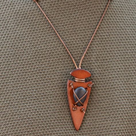 Shiny Brown Cording Crisscrosses Across The Front Of A Refreshing Black Stone, Knotting The Colorful Accent In Place Across The Front Of A Brown Leather Arrowhead Pendant For An Earthy Look. Features An Adjustable Sliding Knot Closure. (1921) Men’s Leather Jewelry, Wood Jewellery Handmade, Pinecone Jewelry, Camp Jewelry, Flint Napping, Leather Bracelet Tutorial, Mens Leather Jewelry, Crow Pendant, Adjustable Sliding Knot