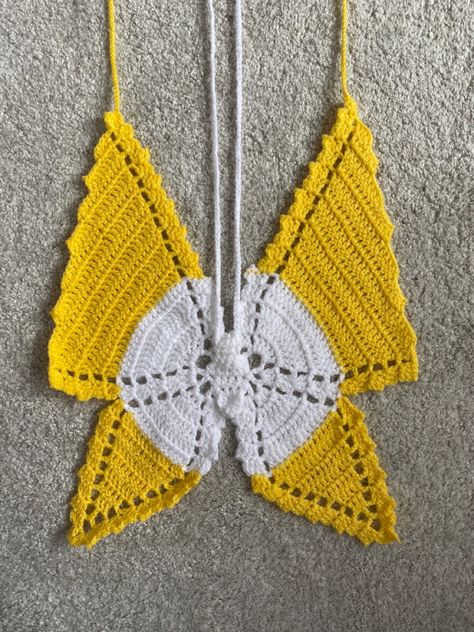 Pictured is a crochet butterfly top laid flat on a carpeted surface. The bold white and yellow colours stand out in an ombré effect. Butterfly Crochet Top, Crochet Clothes Butterfly, Butterfly Crochet Top Tutorial, Top Mariposa Crochet, Crochet Butterfly Top Pink, Yellow Ombre, Butterfly Top, Crochet Butterfly, Crochet Business