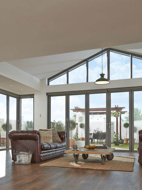 Ideal for impressive vaulted ceilings, trapezoid windows can turn unused space into a gateway for natural light. Usually positioned above a set of traditional windows, trapezoids are bespoke made to fit the shape of your roof, drawing sunlight inside and utilising redundant walls.   From: Origin  Click for more window ideas to bring light into your self build Vaulted Ceiling Living Room, Contemporary Living Room Design, Sliding Door Design, House Extension Design, Windows Exterior, Living Room Windows, Window Styles, Industrial House, Bifold Doors