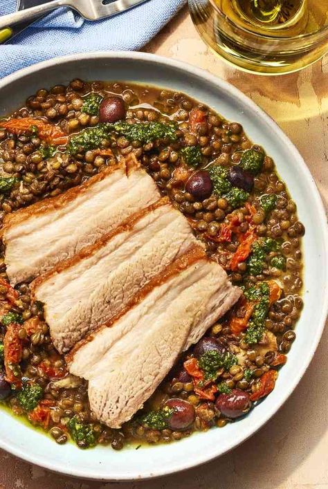 This braised pork belly recipe features wine, sun-dried tomatoes, olives, and pistou with lentils for a comforting dinner. Pork Belly Slices, Comforting Dinner, French Lentils, Braised Pork Belly, Pork Belly Recipes, One Pot Dinners, Braised Pork, Lentil Recipes, Sun Dried Tomatoes