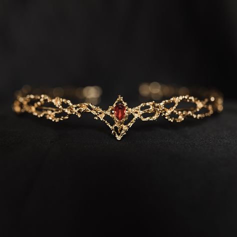 King's Crown features a beautiful gold colored metal braid formed into a circle highlighted by a red crystal at the center of the forehead. King's crown is tapered to fit just right and add the perfect touch.  Circumference: 6.5 Inches Height of Center: 1.25 Inches Ring Height: 0.25 Inches Crown is a disconnected circle and is adjustable to fit most hair styles and head shapes.  All items ship from Michigan, USA. WARNING: CHOKING HAZARD This item is not intended for use by children under the age of 5 years old.  There are small pieces that could fall off and create a choking hazard.  All use of this product by any minor, child or dependent should be supervised by an adult 18 years of age or older. Red Circlet Crown, Golden Circlet Crown, Gold Circlet Crown, Gold And Red Jewelry, Targaryen Jewelry, Blood Crown, Red And Gold Crown, Forehead Crown, Red And Gold Jewelry