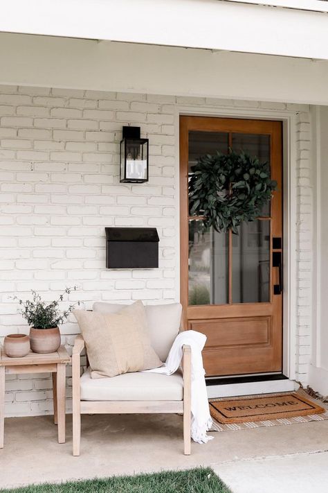 Get inspired to decorate your front porch with a cozy outdoor chair, potted plants and other neutral outdoor furniture and home decor. Follow Halfway Wholeistic for more front door inspiration and home exterior finds. Condo Front Porch Ideas, Front Door Sitting Area, Small Front Porch Furniture Ideas, Small Front Porch Seating Ideas, Small Front Porch Seating, Front Porch Seating Area, Front Porch Chairs Ideas, Diy Front Porch Ideas, Narrow Front Porch