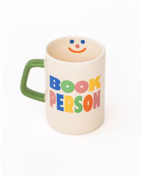 cream ceramic coffee mug with green handle and  colorful 'book person' across the front and smiley face inside Bookish Gift Ideas, Mug Cup Design, Mug Design Ideas, Coffee Mug Designs, Book Mug, Feel Deeply, Fun Mugs, Book Merch, Vintage Mug