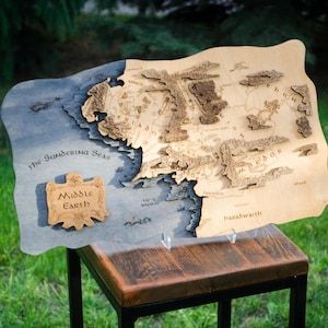 This wooden map makes for a unique and thoughtful gift for lovers of fantasy, ideal for hobbitcore decor or as a magical elven-inspired present. It beautifully captures the iconic locations of Middle-earth, from Rivendell’s serene elven halls and the mighty city of Minas Tirith, to the vast plains of Rohan and the treacherous peaks of Mount Doom. Hobbitcore Decor, Mount Doom, Minas Tirith, Map Wood, Map Artwork, Wooden Map, Wood Map, Map Canvas, Map Wall Art