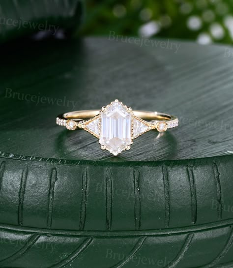 Elongated Hexagon cut Moissanite Engagement ring Vintage Yellow gold Triangle Diamond ring Half eternity marriage ring  ~~About This Ring~~ ~Main Stone: 5*9mm Long Hexagon cut Moissanite  ~Side Stone: 0.24ct Moissanite or 0.24ct Diamond ~The band width is about 1.5mm The material is solid gold(14k/18k White, Yellow, Rose gold available). Ring size can be chosen from the drop menu(3US-9US can be chosen from the drop menu, Please contact me for other ring size). Need other gemstones or metal , Please contact me for a quote. ~~Production Time~~ All rings are handmade to orders, it will take 2 to 3 weeks, If you are in a hurry, Please contact me before placing the order. ~~30 Days Money Back~~ I offer 30 days return service, After receiving the items, If you are not satisfied(Non-quality issue Hexagon Diamond Ring Gold, Hexagon Diamond Cut Wedding Rings, Long Hexagon Engagement Ring, Gold Diamond Hexagon Ring, Luxury Hexagon Wedding Ring, Elongated Hexagon Engagement Ring, Hexagon Wedding Ring, Engagement Ring Hexagon, Geometric Engagement Ring