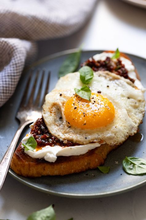 Elevate your morning breakfast with this gourmet Goat Cheese Toast. Warm slices of bread spread with a layer of tangy goat cheese, then topped with creamy poached eggs, and an herby sun-dried tomato sauce. It's quick, easy, and a delicious start to the day any day of the week! Goat Cheese Breakfast Toast, Breakfast With Goat Cheese, Breakfast Ideas With Goat Cheese, Goat Cheese Recipes Breakfast, Goat Cheese Eggs, Eggs Goat Cheese, Goat Cheese Breakfast, Goat Cheese Toast, Tomato Spread