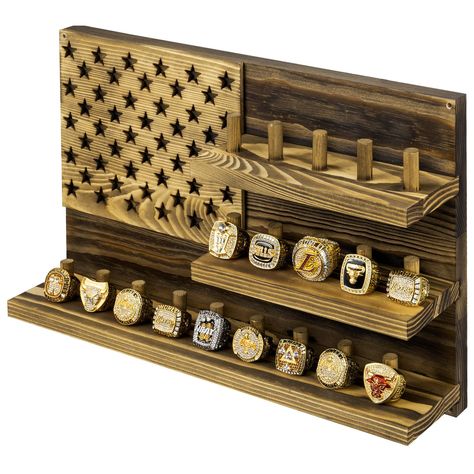 PRICES MAY VARY. 3-tiered wall mounted wooden U.S. Flag designed jewelry storage display shelf and ring holder to display sports championship rings Featuring 19 built-in pegs that each hold a single large sports championship ring, or several men’s or women’s standard jewelry rings Constructed of solid wood with a rustic burnt brown finish with an ornate cutout of stars resembling the patriotic American national flag Easily mount this ring storage organizer using the pre-drilled holes and compati Championship Ring Display Ideas, Closet Storage Accessories, Jewellery Storage Display, Jewelry Display Case, American Flag Stars, Ring Display, Ring Storage, Championship Rings, Storage Display