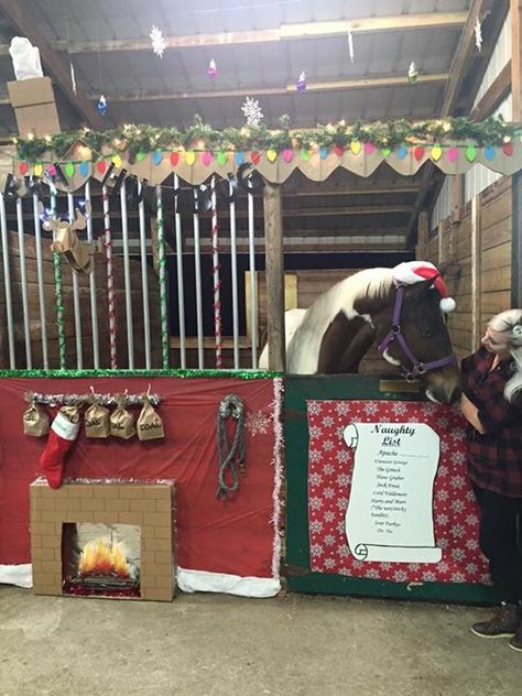 A wider view of Apache's stall... My horse's Christmas stall for our 2015 stall decorating contest... I revisited our "Naughty List" theme from a few years back. His name is at the top of the naughty list (as always!), coal in his stocking that is hanging from the mantle above the fireplace, and new this year... A cardboard mounted deer head (from target) and dollar store lights on its antlers to hang over the mantle. There's a chimney with "smoke" coming out at the top of his stall and I hung s Christmas Stall Decorations, 4h Horse Stall Decorations, Reindeer Stables Hallway Decoration, Fair Horse Stall Decorations Ideas, Horse Stable Christmas Decorations, Christmas Horse Stall Decorating Ideas, Horse Stall Christmas Decorations, Christmas Horse Stall, Christmas Decorated Horse Stall