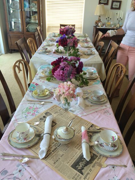 Vintage linens are used to top this tea party table, along with pages from a newspaper dated 1947. Teacups and saucers are set up mix and match for a shabby chic look.  Sterling spoons were bent into circles for napkin rings, with vintage shell buttons as decoration. Mix Match Tea Party, Mix Match Tea Party Table Settings, Table Setting Guide, Tea Party Table Settings, Jazz Night, Group Dinner, Vintage Table Setting, Tea Party Table, Tea Party Setting