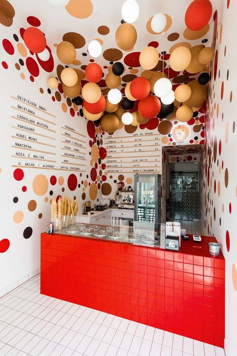 This modern ice-cream shop features colorful suspended balls and lighting from the ceilings, and dots on the walls complement the ball installation on the ceiling. #IceCreamShop #RetailDesign #InteriorDesign Ice Cream Shop Design, Ball Installation, Creative Ice Cream, Katowice Poland, Ice Shop, Ice Cream Business, Bubble Tea Shop, Gelato Shop, Interior Vintage