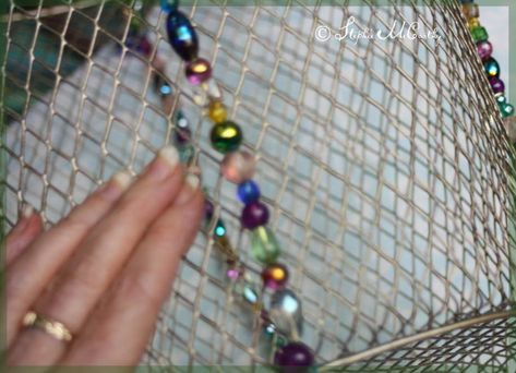 We wired an ordinary mesh basket with about 800 glass beads. It would be dazzling as a storage container, but we flipped it upside down and are using it as a colorful lampshade. We wired the open end with three rows of beads … The other rim was wired with two rows. We made four stripes up the sides and used a vintage necklace to make some graceful curves. This is not very hard to make, but it does take lots and lots of beads … about 800 more or less … approximately 7mm in size, and tra… Basket Lampshade Diy, Basket Lampshade, Picnic Table Makeover, Diy Drum Shade, Lampshade Diy, Colorful Lamp Shades, Glass Bead Crafts, Beaded Lampshade, Beaded Lamps