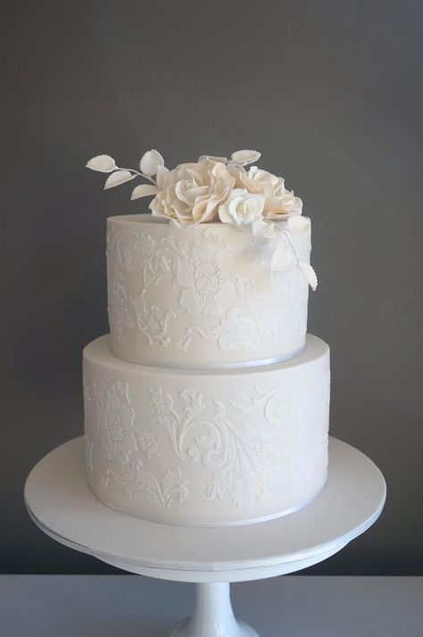 Ivory cake with white stenciling and sugar flowers . Cake Envy Melbourne Lace Stencil Wedding Cake, White On White Stencil Cake, Wedding Cake With Stencil Design, Wedding Cake Stencil Patterns, Wedding Cake Lace Design, Stencil Wedding Cake Designs, Stenciled Wedding Cakes, White Stencil Cake, Stencil Wedding Cake