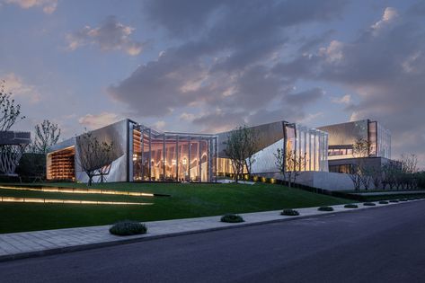 the community center is divided between three buildings with an undulating exposed timber structure clad in hexagonal aluminum plates. Urban Design Architecture, Community Centre, Facade Lighting, Timber Structure, Interesting Buildings, Chinese Garden, Roof Structure, Community Center, Geodesic Dome