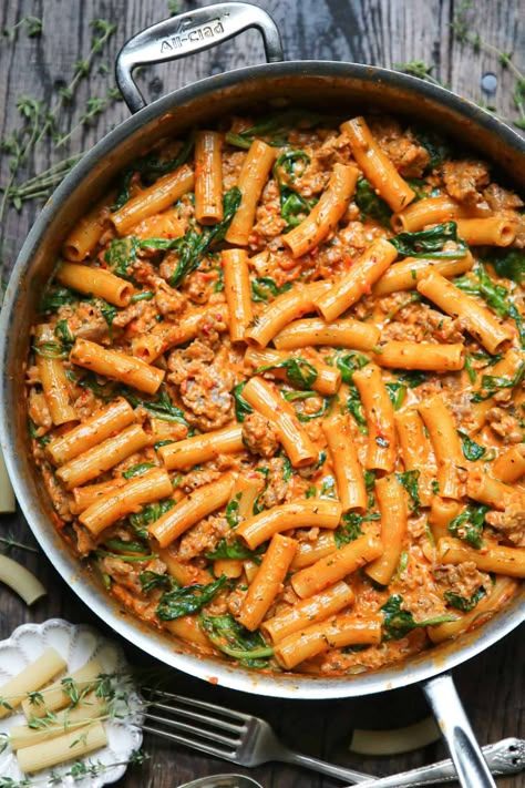 creamy sausage rigatoni with tomato sauce and spinach in a stainless steel skillet. Sausage Rigatoni Pasta, Creamy Sausage Rigatoni, Sausage Rigatoni Recipes, Rigatoni Pasta Recipes, Rigatoni Recipe, Sausage Spinach Pasta, Spicy Sausage Pasta, Sausage Rigatoni, Rigatoni Recipes