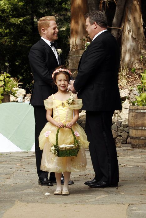 Here is one of the families from the show "Modern Family" on their wedding day.  The gay family consists of partners Cam and Mitchell and their adopted daughter Lily.  Modern Family promotes gay marriage and the possibility of gays starting a family of their own.  This proves that even though you're gay, you can still lead a happy, functional life and start a family just like any family with different sexual orientations. Cam Modern Family, Modern Family Lily, Eric Stonestreet, Tv Weddings, Smallest Wedding Venue, Family Tv, Family Funny, Family Humor, Modern Love