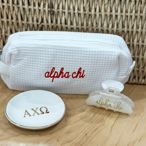 Select your assortment of Alpha Chi Omega gifts to make your own gift set! We'll package in a cellophane bag tied with ribbon in the sorority colors! Choose any combination of the these popular items, including the super trendy waffle weave bag, ring/pin dish with gold trim and the fun sorority embellished hair clip.  BAG: * 7.75" x 3.5" x 2.5" OR 7" x 4.75" x 3.5" * Poly/cotton waffle weave fabric exterior * Vinyl lined interior and one interior pocket RING/PIN DISH: This ceramic dish is 4" x 4" white ceramic porcelain with gold Greek letters. HAIR CLIP: 3-1/4" wide x 2.5" tall with heavy-duty claw design Personalized in high-quality printed vinyl on ONE side of the clip. ~ OTHER INFORMATION ~ Normal turnaround varies by item and is indicated in the shipping information. See shop announce Alpha Phi Baskets, Sorority Gift Ideas, Big Little Basket Theme, Sorority Gift Baskets, Little Baskets Sorority Ideas, Axo Merch, Sorority Little Gifts, Alpha Chi Omega Canvas, Adpi Recruitment