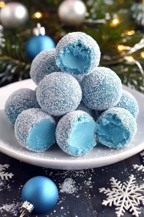 Blue Christmas Truffles start with a smooth white chocolate ganache, beautifully tinted by blue curacao, which adds a touch of warmth as they melt in your mouth. These truffles deliver a luscious blend of creamy white chocolate with a subtle citrusy note. Step into the world of holiday indulgence with these Blue Christmas Truffles—a dreamy Blue Christmas Truffles, Blue Pastries, Winter Wonderland Desserts, Winter Wonderland Treats, Christmas Themed Food, Christmas Themed Desserts, Irish Cream Truffles, 21 Dinner, Blue Curacao Liqueur