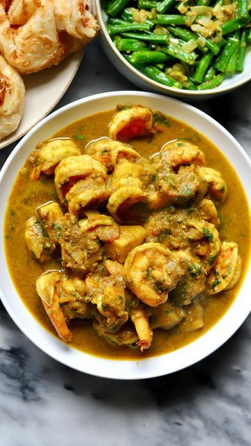 Travelandmunchies on Instagram: "It is Carnival in Trinidad and Tobago 🎉🙌💃🏿 and what better way to show some love that to celebrate with some curry shrimp! I ate this meal on my first day in Trinidad and Tobago last year and I am still dreaming of it. So naturally I wanted to replicate it. Truly one of the most delicious dishes there is! You can’t really go wrong with curry shrimp, buss up shut, pumpkin and bodi (green beans). The recipes for pumpkin and bodi are coming up. This recipe is pr Caribbean Curry, Recipes For Pumpkin, Caribbean Kitchen, Trinidad Food, Trinidad Recipes, Trini Food, Caribbean Food, Curry Shrimp, Curry Dishes