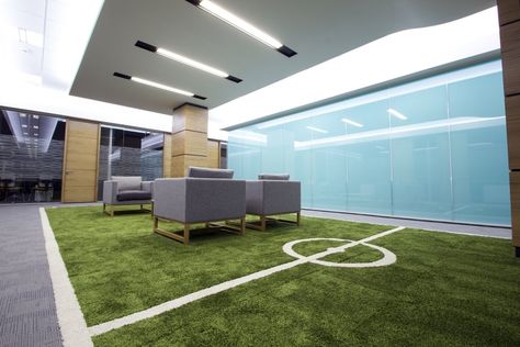 Why not get a little bit creative and do something very different with your office? Leeds United had a football pitch made out of carpet inserted into the middle of their office and we think it looks brilliant! Club Design Interior, Commercial Interiors Office, Sport Bar Design, Leeds United Football, Sports Office, Leeds England, Cool Office Space, Retail Space Design, Corporate Office Design