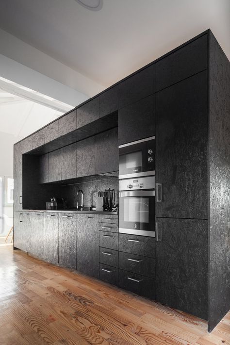 A black-painted OSB box houses a occupies a kitchen on one side in this… Painted Osb, Osb Furniture, Cabinets Ideas, Converted Barn, Box Houses, Black Kitchen, Black Cabinets, Black Kitchens, Cabinet Design