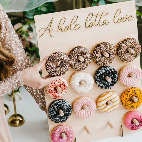 ❤ Donut wall - the ultimate display solution for showcasing delicious treats at  events, parties, and weddings. Crafted with high-quality materials and a stylish  design, this stand adds a touch of charm to any dessert spread.  ❤ We offer four unique design options and a variety of text choices, allowing you to  select the perfect combination that complements your party theme or event, whether  it's a donut party, bridal shower, first birthday, or baby shower decor. With our range  of designs an Donut Stand Display, Donut Cart, Decorations For Wedding Reception, Donut Holder, Donut Wall Wedding, Table Display Stand, Dessert Table Display, Fall Baby Shower Themes, Donut Display