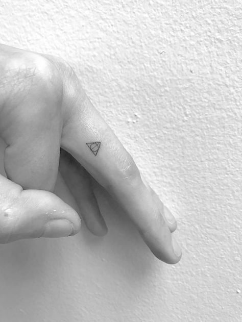 Deathly Hallows symbol tattoo on the left finger. Deathly Hallows Tattoo Finger, Minimal Harry Potter Tattoo, Slytherin Tattoo Minimalist, Microtattoo For Women, Harry Potter Minimalist Tattoo, Harry Potter Tattoos Minimalist, Minimalist Harry Potter, Tiny Harry Potter Tattoos, Slytherin Tattoo